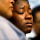 Tears stream down the cheeks of the daughter of Alfred Olango while she is embraced by her mother.